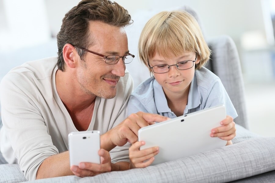 Father and son using smartphone and tablet