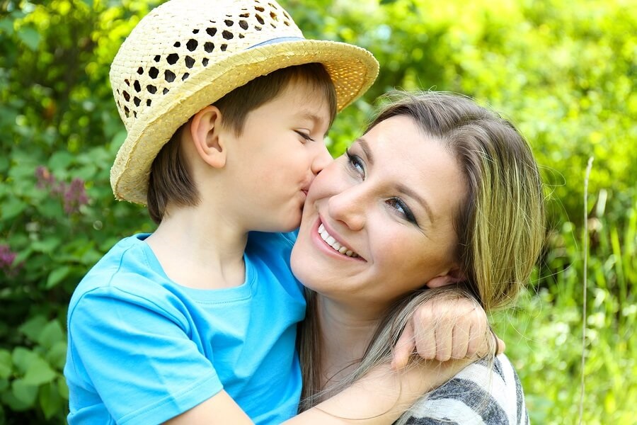 Young boy kissing mother on cheek